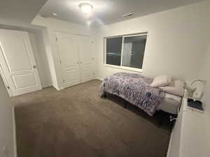 Carpeted bedroom with a closet and baseboards