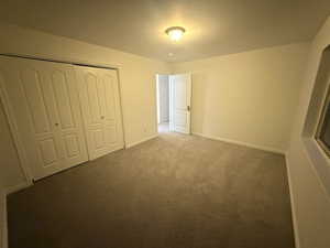 Unfurnished bedroom with carpet flooring and a closet