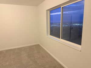 Carpeted empty room featuring baseboards
