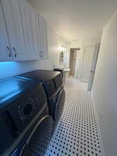 Washroom with washing machine and dryer and baseboards