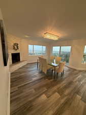 Dining room with wood finished floors, plenty of natural light, and a fireplace
