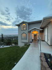 Doorway to property featuring stucco siding and a yard