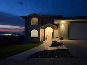View of front of property with stucco siding, driveway, an attached garage, and a front yard
