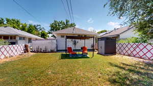 Rear view of property with a fenced backyard, a shed, and a gazebo
