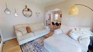 Living area with arched walkways and wood finished floors