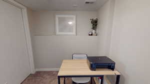 Carpeted office space with baseboards and a textured ceiling
