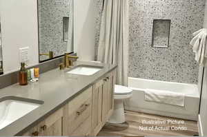 Full bath featuring double vanity, wood finished floors, and shower / tub combo