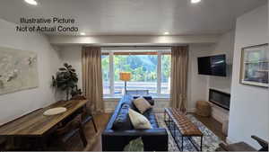 Living area featuring recessed lighting, wood finished floors, and a glass covered fireplace