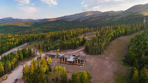 View of property location with a mountainous background and a heavily wooded area