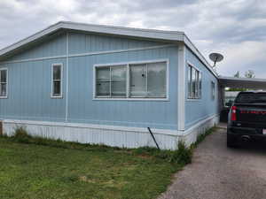 View of home's exterior with a lawn and an attached carport