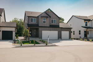 View of front of house featuring board and batten siding, roof with shingles, driveway, and a garage