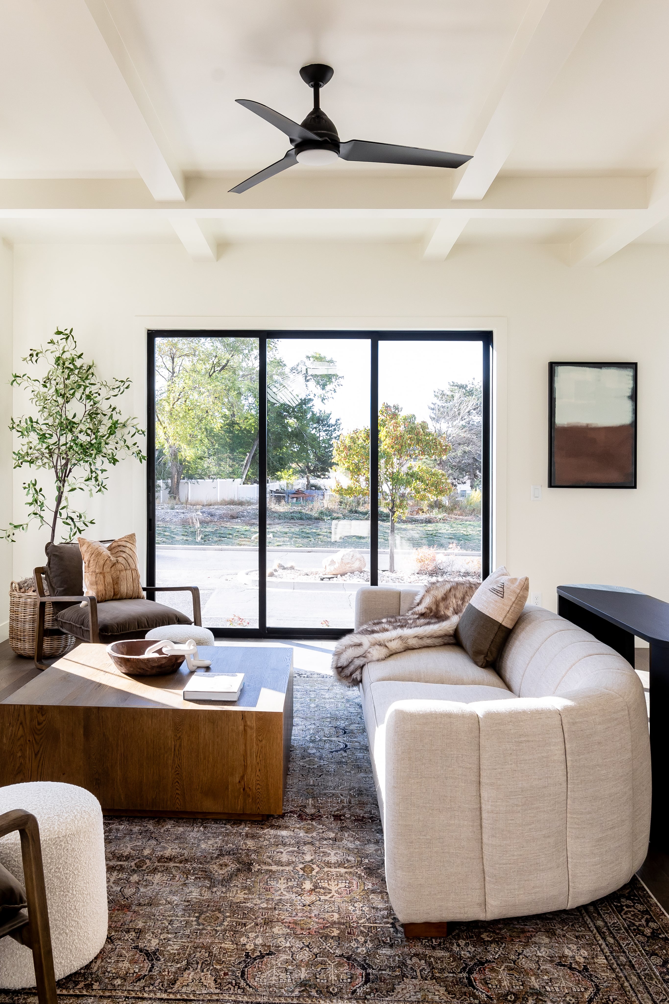 Living area with beamed ceiling and a ceiling fan