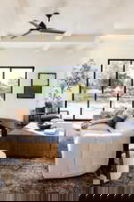 Living area with beamed ceiling and a ceiling fan