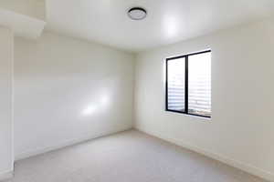 Empty room featuring carpet flooring and baseboards