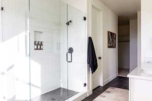 Full bath with vanity, a shower stall, and tile patterned flooring