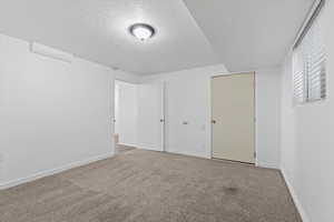 Unfurnished bedroom featuring a textured ceiling and carpet floors