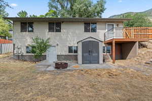 Rear view of house featuring a storage unit, an outdoor fire pit, and a deck with mountain view