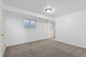 Unfurnished bedroom featuring a textured ceiling and carpet flooring