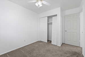 Unfurnished bedroom featuring carpet flooring, a closet, and ceiling fan