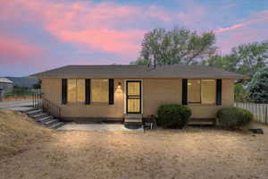 Single story home featuring entry steps, brick siding, and roof with shingles
