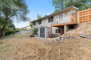 Back of property featuring a storage shed and a fenced backyard