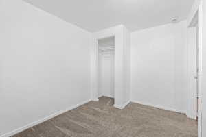 Unfurnished bedroom with carpet flooring and a closet