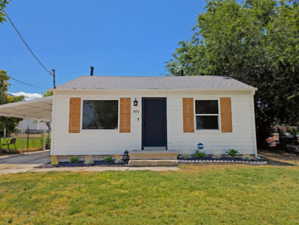 Front of house featuring an attached carport, and fully fenced yard