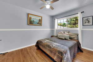 Bedroom with wood finished floors and ceiling fan