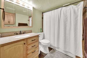 Bathroom featuring a textured ceiling and vanity
