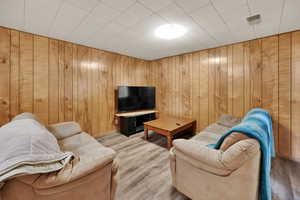 Living area with light wood finished floors and wood walls