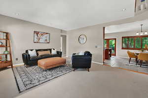 Living area with recessed lighting, a chandelier, and carpet floors