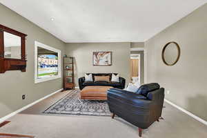 Carpeted living room featuring a textured ceiling and recessed lighting