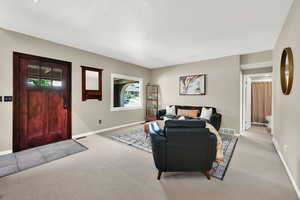 Living area with light colored carpet and a textured ceiling