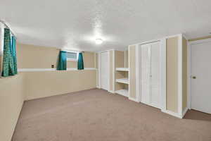 Basement with a textured ceiling and carpet floors