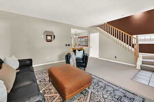 Living area featuring stairs and carpet flooring