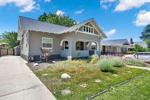 View of front of house featuring a shingled roof, a porch, driveway, and a garage