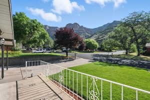 Surrounding community with a mountain view and a lawn