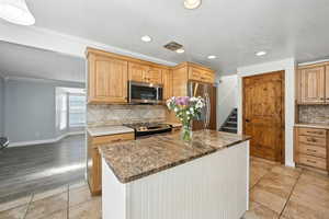 Kitchen with recessed lighting, a textured ceiling, appliances with stainless steel finishes, tasteful backsplash, and light tile patterned floors