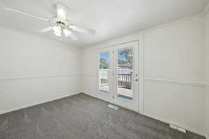 Unfurnished room featuring carpet floors, ornamental molding, and a ceiling fan