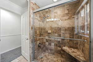 Full bath featuring a stall shower and crown molding