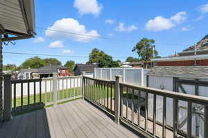 Wooden terrace with a fenced backyard and a storage unit
