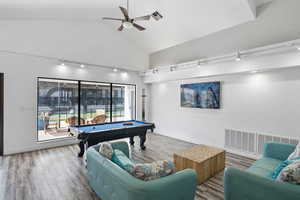 Playroom featuring rail lighting, ceiling fan, billiards table, wood finished floors, and high vaulted ceiling