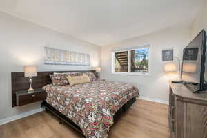 Bedroom with wood finished floors and baseboards