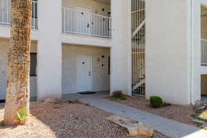 Doorway to property with stucco siding and a balcony