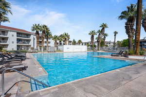 Community pool with a patio area and a residential view