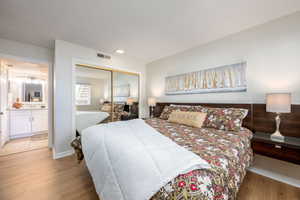 Bedroom with wood finished floors and a closet