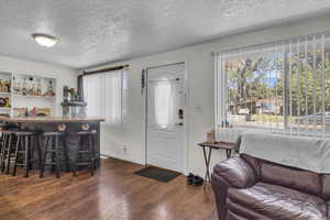 Entrance foyer featuring a bar, wood finished floors, and a textured ceiling