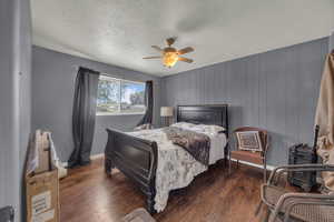 Bedroom featuring hardwood / wood-style floors, a textured ceiling, and a ceiling fan