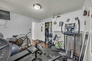 Workout room featuring wood finished floors and baseboards