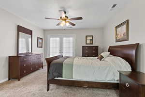 Bedroom with access to exterior, light colored carpet, french doors, and ceiling fan